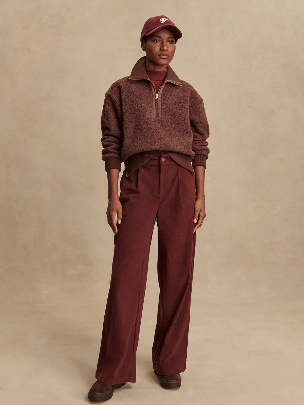 Model wearing Varley Roselle fleece in Deep Mahogany, styled with athleisure pants