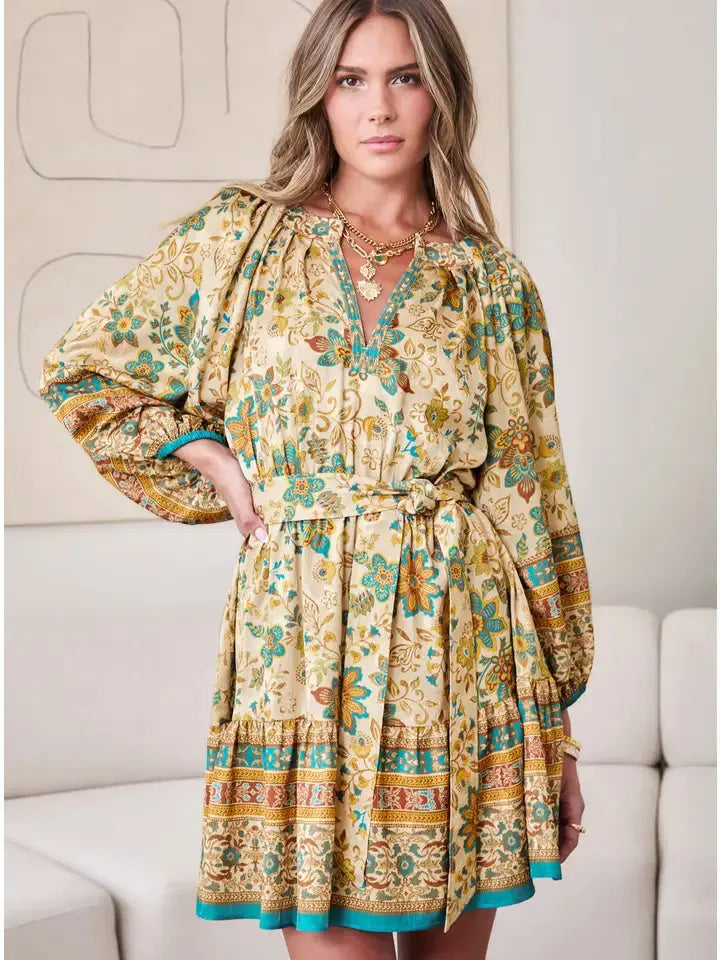 Mini dress with all‑over paisley border print, split V-neckline, ¾ sleeves, self-fabric waist belt, and tiered ruffled hem