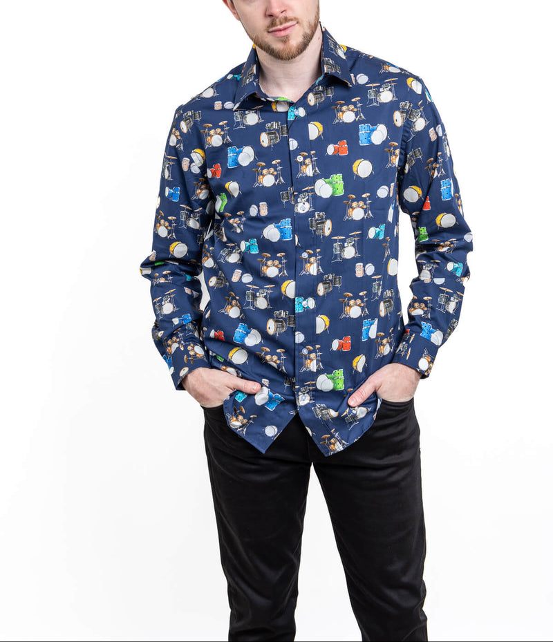 Man wearing a patterned shirt with a white background with drums
