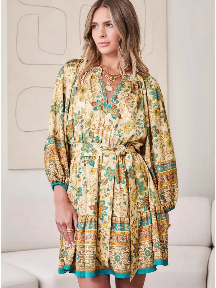 Front view of paisley border printed mini dress with split V-neck and self belt