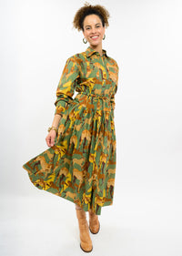 Model wearing a green Uncle Frank horse print midi shirt dress with a tie waist