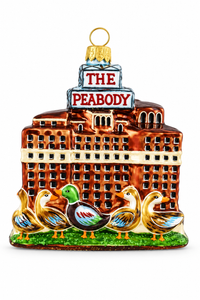 A decorative ornament shaped like a building labeled 'THE PEABODY' with four ducks in front on a green grass-like base, shown on a plain white background.