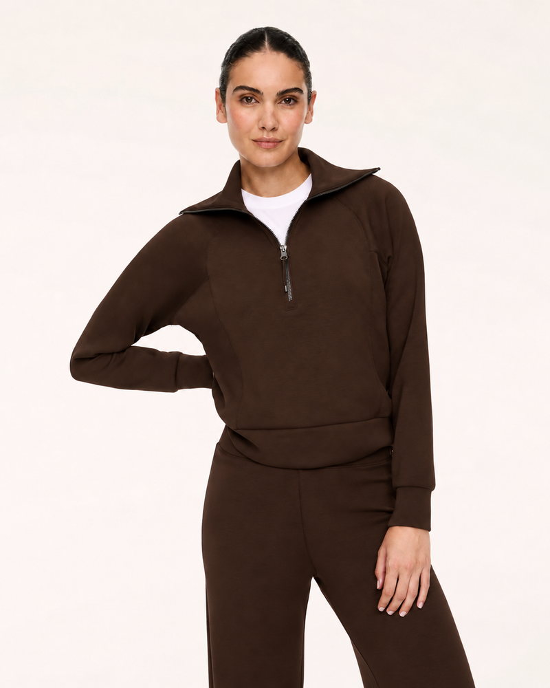 Model wearing the SPANX AirEssentials Half Zip in Umber Root brown