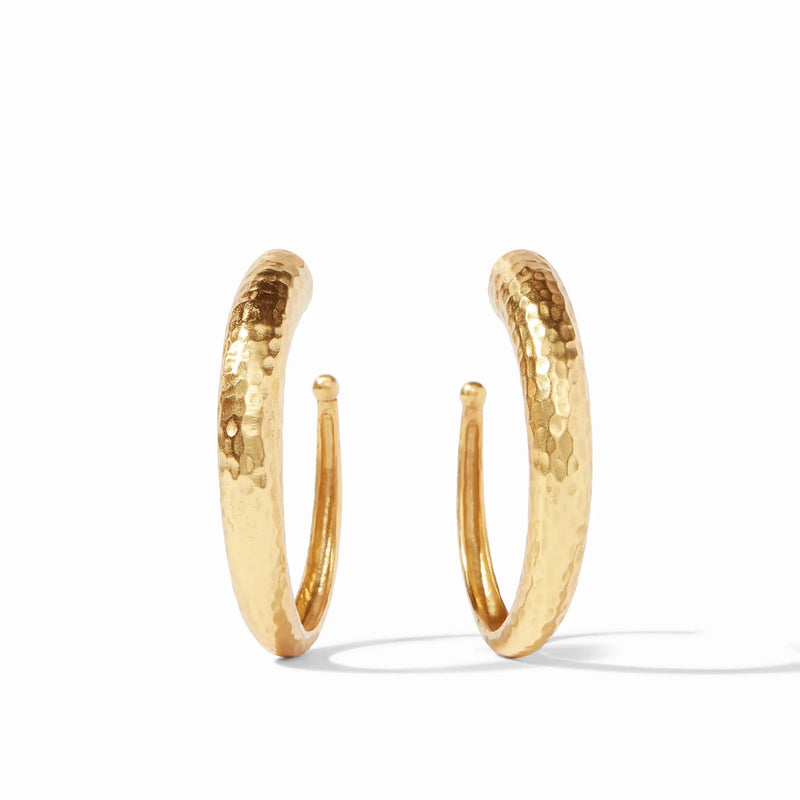 Pair of large gold hoop earrings by Julie Vos displayed on neutral background

