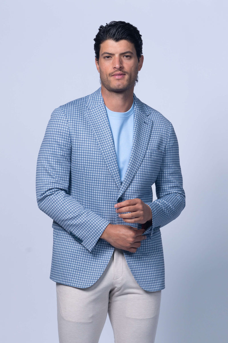 Man wearing a light blue checkered blazer over a light blue shirt on a white background