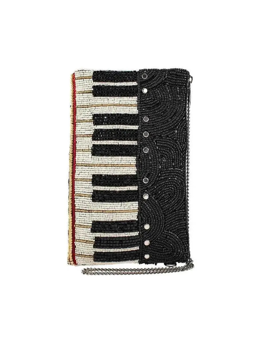 Mary Frances piano-shaped crossbody bag with white, black, and gold hand-laid beads and removable chain strap.